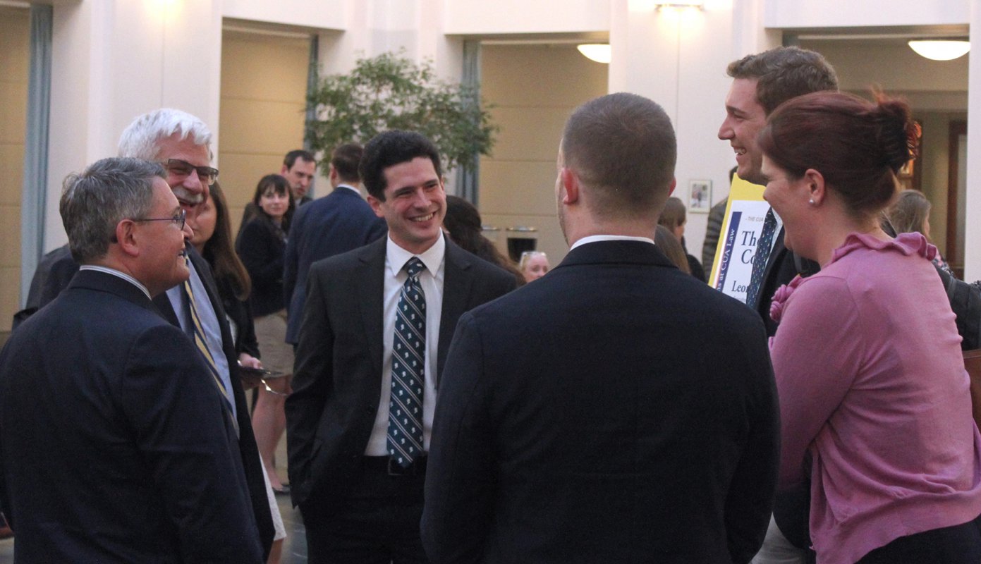 Leonard Leo talking with some students and alumni in the law school atrium